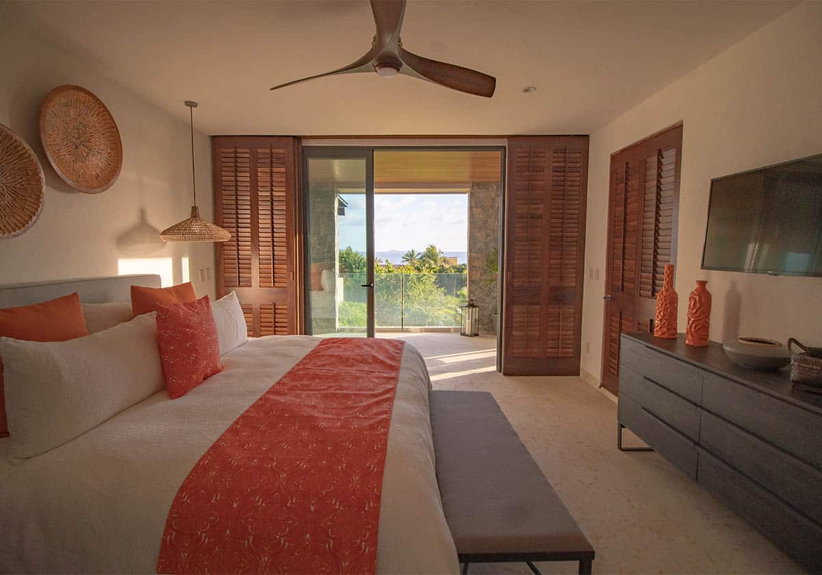 Bedroom with balcony having king size bed having modern looking design and some art displayed on the wall